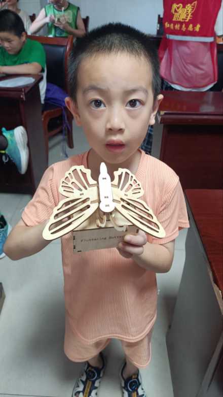 圖為方遠(yuǎn)航小朋友向志愿者展示他的成果
