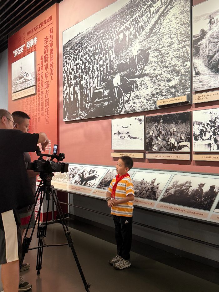 (此處添加照片:渡江勝利紀念館內少先隊員在對展廳進行講解)