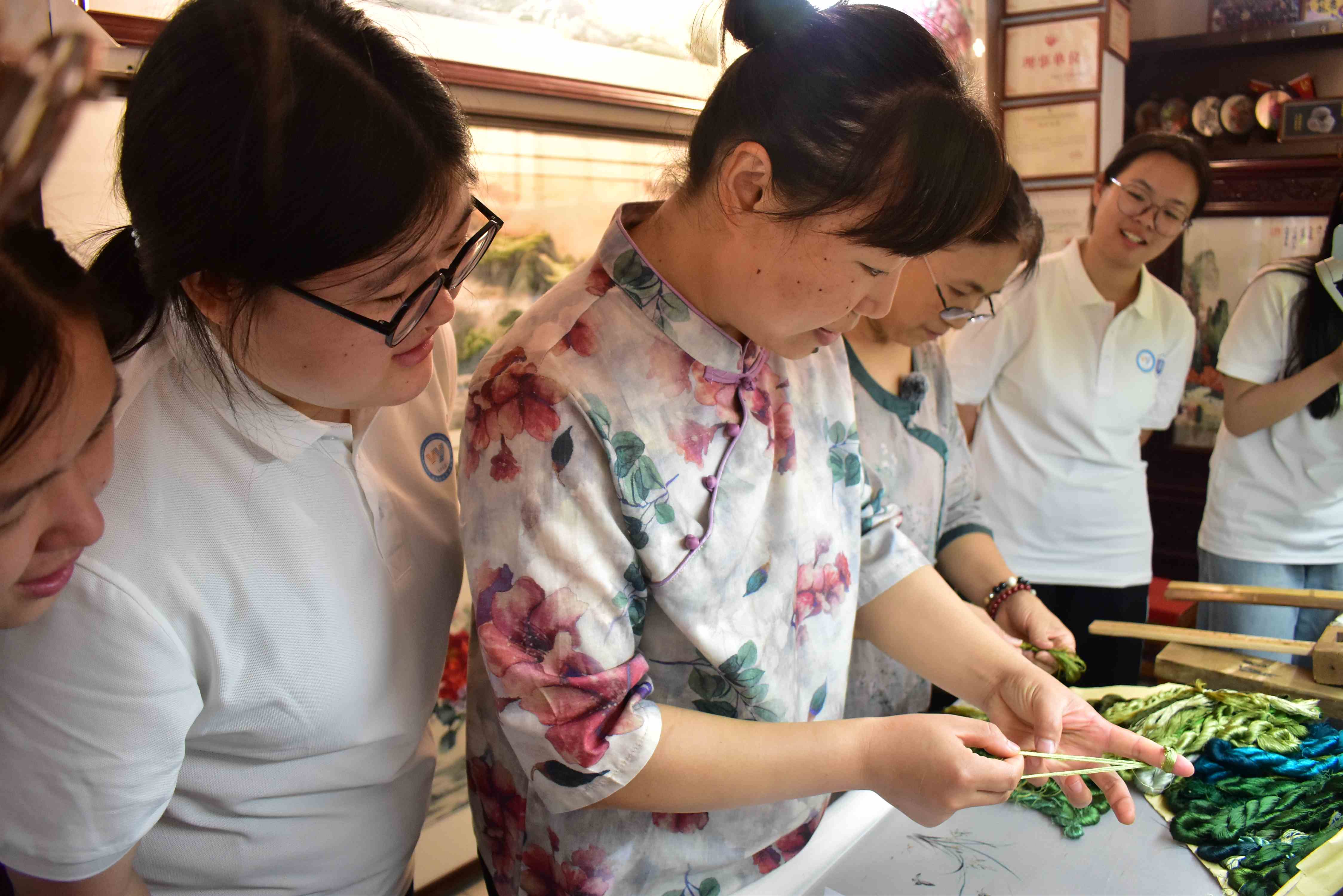 圖為實踐隊隊員在向汴繡傳承人蔡敬學習編線。龔雨帆 攝